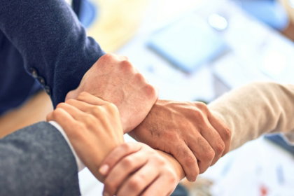 team-members-gripping-wrists-in-unity-gesture.jpg team members gripping wrists in unity gesture
